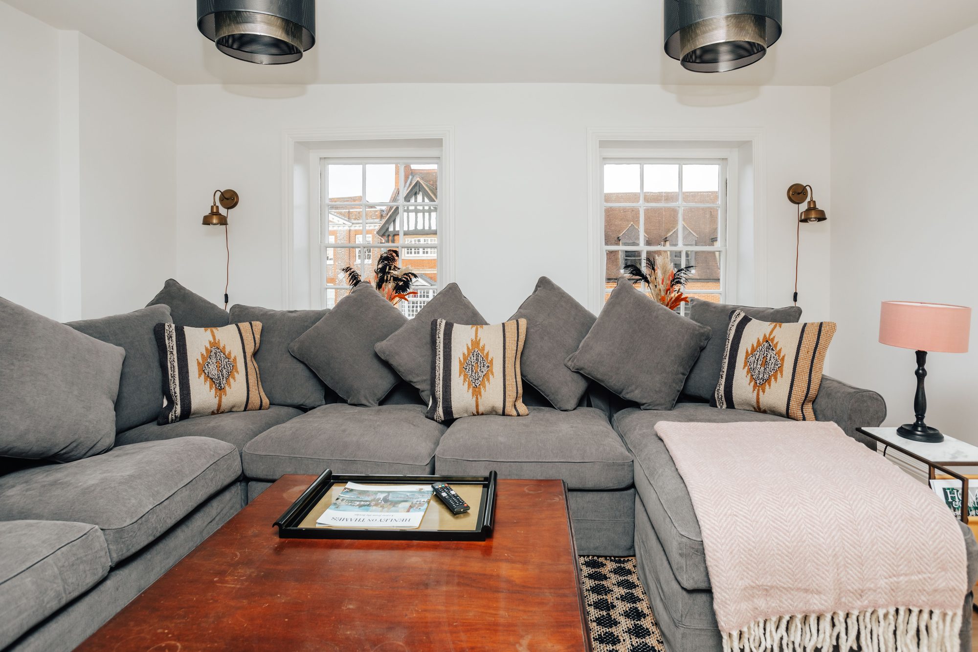Swan's Nest sitting room with its U-shaped grey sofa and tall windows